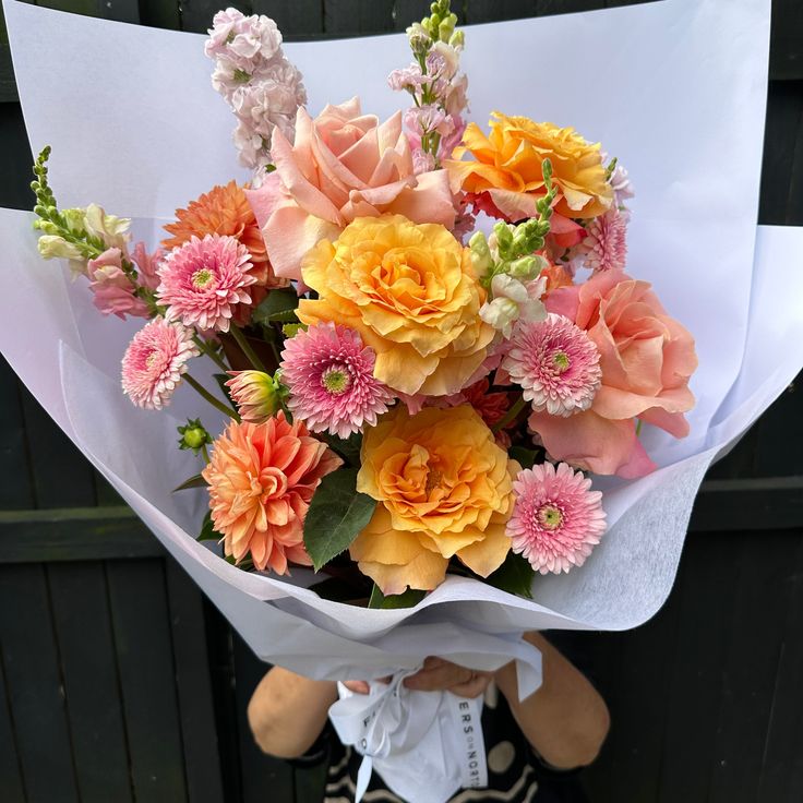 a person holding a bouquet of flowers in their hands