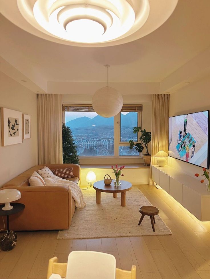 a living room filled with furniture and a flat screen tv mounted on the wall next to a window