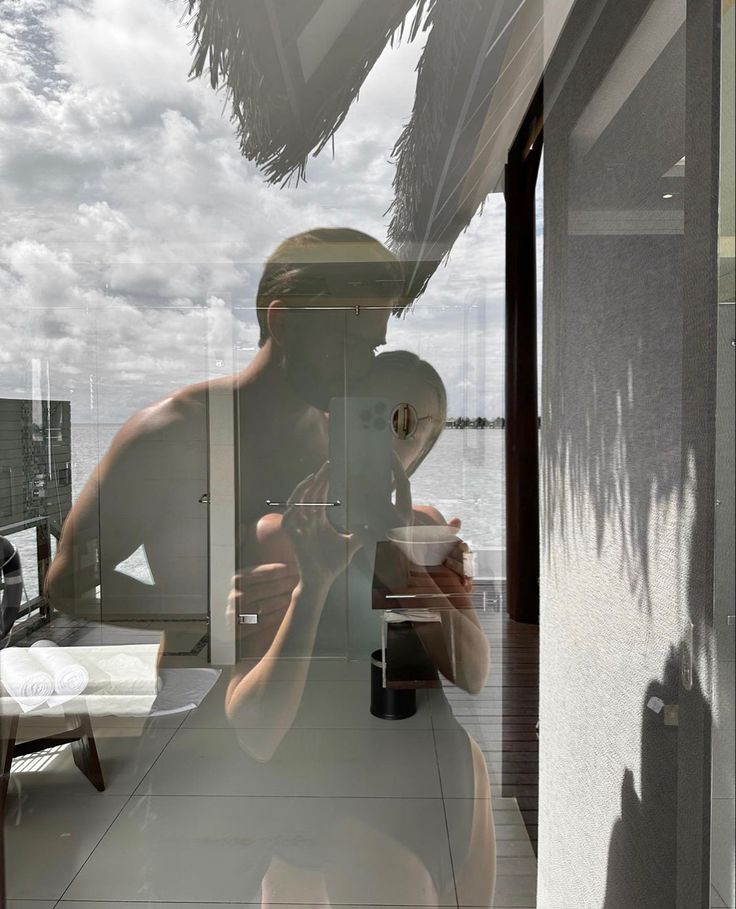 a man is taking a photo in the reflection of another person's face and hat