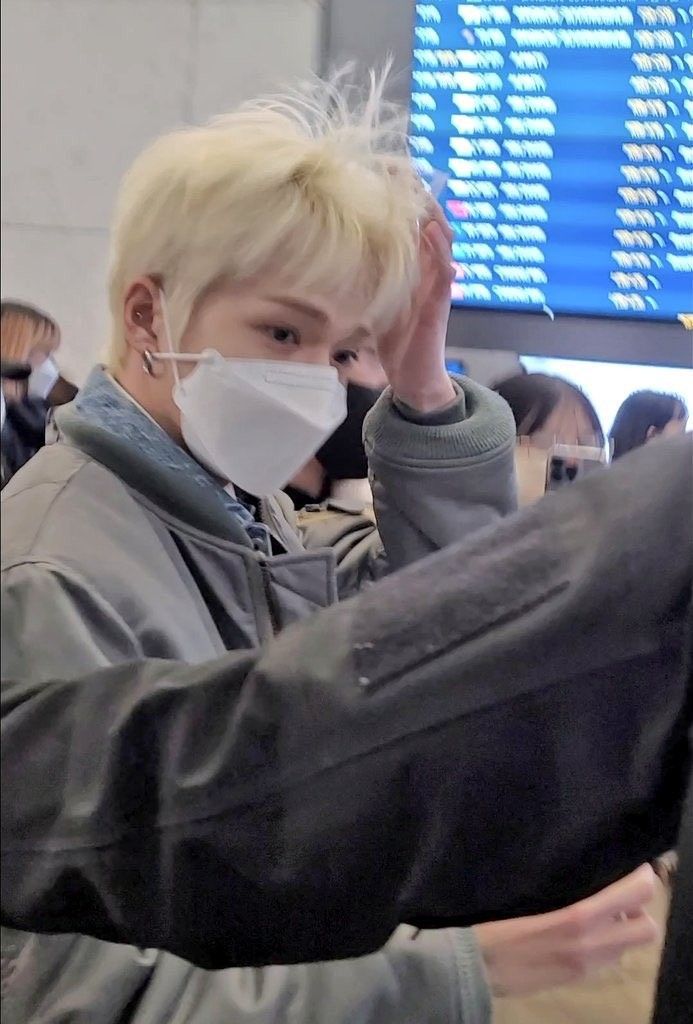 a man wearing a face mask while standing in an airport