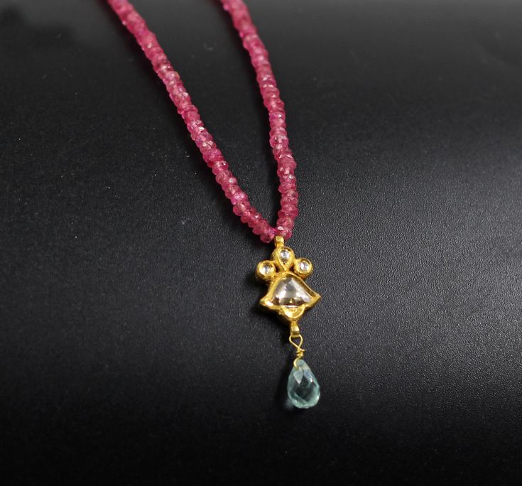 Ruby beads necklace 18k gold pendant studded with real diamond polki slices hanging aquamarine drop. Rubies were thought to guarantee good health, wealth, wisdom, and success in love. They've became some of the most sought-after gems. The diamond is LIGHT, life, the SUN; it is an emblem of purity and perfection, of invincible spiritual power, and it is the stone of commitment, faithfulness Mughal style pendant handcrafted in 22k gold, natural and conflict-free Australian diamond slices, and aqua Yellow Gold Kundan Necklace With Gemstone For Gift, Diamond Pendant Fusion Necklace, Diamond Pendant Necklace In Fusion Style, Festival Gift Kundan Necklace With Rose Cut Diamonds, Festivals Gift Kundan Necklace With Rose Cut Diamonds, Festive Gift Kundan Necklace With Rose Cut Diamonds, Fusion Style Diamond Pendant Necklace, Traditional Diamond Round Pendant Jewelry, Kundan Necklace With Round Pendant For Gift