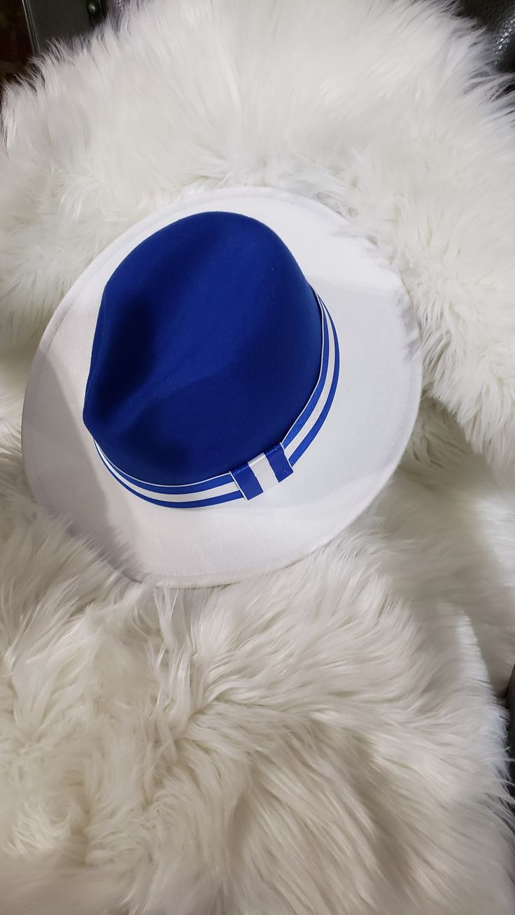 Blue and White, She's Out of Sight Walk into any space with this lovely blue and white classic fedora and watch the heads turn. This fedora fits a medium dome super comfy.  Wearing big hair?  That's fine!  You can wear this statement piece tilted back or shouldered to the side.  The fedora measures 57cm or 22.44 inches. Blue Summer Hats For Day Out, Blue Summer Hat For Day Out, Casual Adjustable Blue Fedora, Trendy Adjustable Blue Fedora, Classic Blue Panama Hat With Curved Brim, Blue Flat Brim Panama Hat For Summer, Blue Summer Hats For A Day Out, Casual Blue Fedora With Short Brim, Blue Wide-brim Hat For Day Out