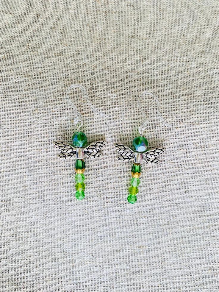 Approximately 2 inches in length, including the plastic earring hooks. The earrings display different shades of greens and yellows. Green Metal Clip-on Earrings For Gift, Green Metal Earrings For Gift, Green Metal Dangle Earrings, Green Beaded Pierced Earrings, Green Metal Beaded Drop Earrings, Nickel Free Green Metal Earrings, Nickel-free Green Dangle Earrings, Nickel-free Green Metal Beaded Earrings, Green Nickel Free Dangle Earrings