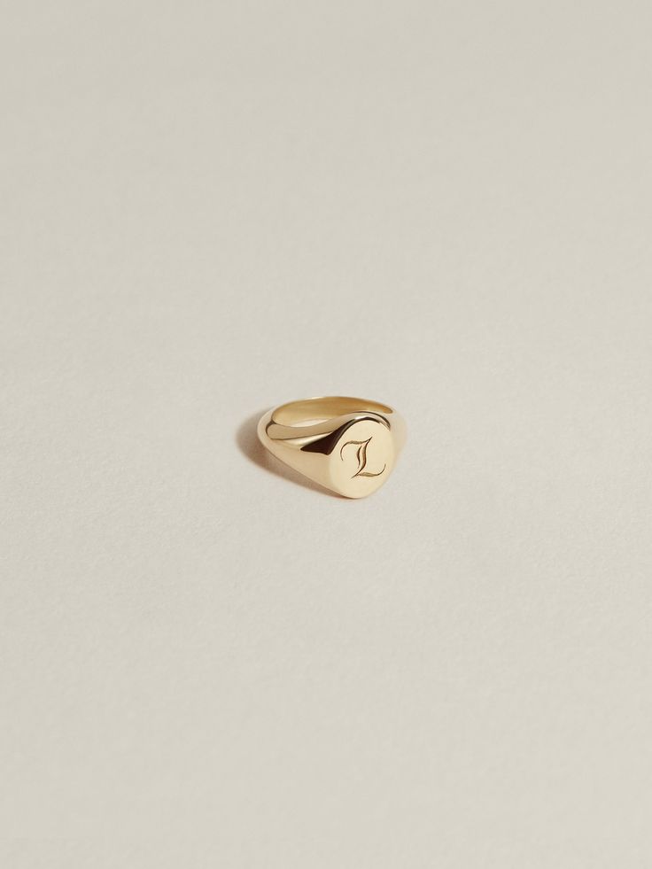 An ultra-petite version of our classic, engravable JH signet ring—interpreted in charm form. Our Baby Signet Charm has an 8mm interior diameter with a signet face that measures 5mm x 6mm. Crafted in 100% recycled 14k gold or sterling silver and available à la carte, paired with a chain (cable, figaro, or curb), or with one of our signature Charm Chains (curb, paperclip) in a length of your choosing. We offer two engraved font options for personalization: laser engraved J.H. Gothic (our entirely Timeless Engraved 14k Gold Initial Ring, Everyday Engraved Heirloom Signet Ring, Timeless 14k Stamped Initial Ring With Round Band, Timeless 14k Gold Engraved Initial Ring, Heirloom Engraved Signet Ring For Everyday Wear, Everyday Heirloom Engraved Signet Ring, Timeless 14k Gold Engraved Ring With Initials, Personalized 14k Gold Timeless Signet Ring, 14k Gold Jewelry With Initials On Round Band