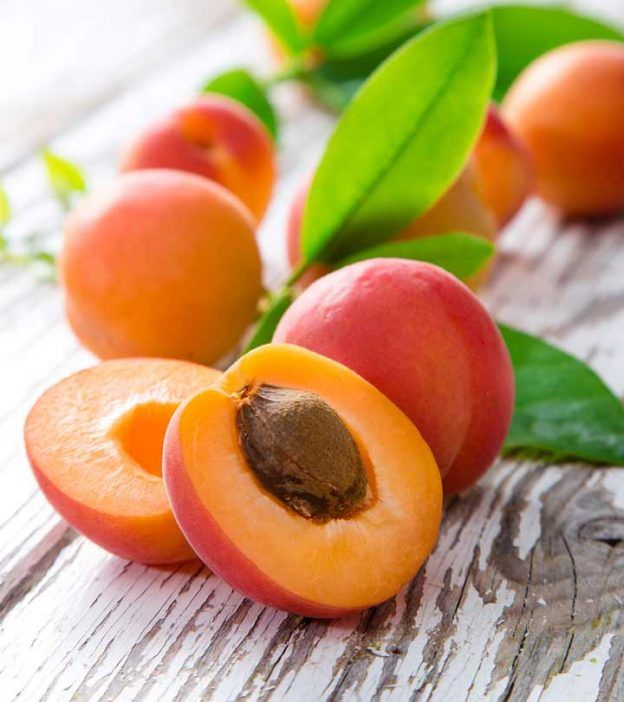 apricots with leaves on a wooden table