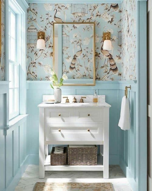 a bathroom with blue walls and floral wallpaper