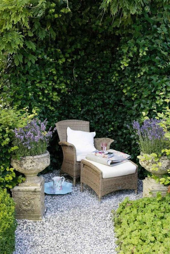 a chair and ottoman in the middle of a garden