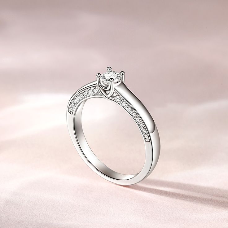 Simple and stunning, this ring showcases a magnificent round cut stone standing tall in the traditional four-prong setting, while additional round stones line the shank. So elegant it needs no further accompaniment, this ring is finished with a bright polished shine. The stones in this engagement ring shine brightly enough to be deserving as a symbol of your love.Carat Weight: 0.275 ctStone Size: 4 mmStone Type: Jeulia® StoneNumber of Stones: 1 Stone Color: Diamond WhiteStone Shape: RoundCarat Weight: 0.648 ctStone Size: 1.1,1.3,1.5 mmStone Type: Jeulia® StoneNumber of Stones: 32 Stone Color: Diamond WhiteStone Shape: RoundWeight: 2.7 gWidth: 1.7 mmHeight: 4.9 mmThickness: 1.2 mmMaterial: 925 SilverPlating Color: Silver Open Crystal Ring With Diamond Prong Setting, Diamond Crystal Ring With Prong Setting, Diamond Crystal Open Ring With Prong Setting, Diamond Crystal Ring With Prong Setting And Open Shape, Diamond White Diamond Ring With Prong Setting For Promise, White Gold Crystal Ring With Diamond Accents For Promise, Elegant Diamond Ring With Accent Stones As Gift, Fine Jewelry Crystal Promise Ring With Prong Setting, Elegant Princess Cut Crystal Ring In Sterling Silver