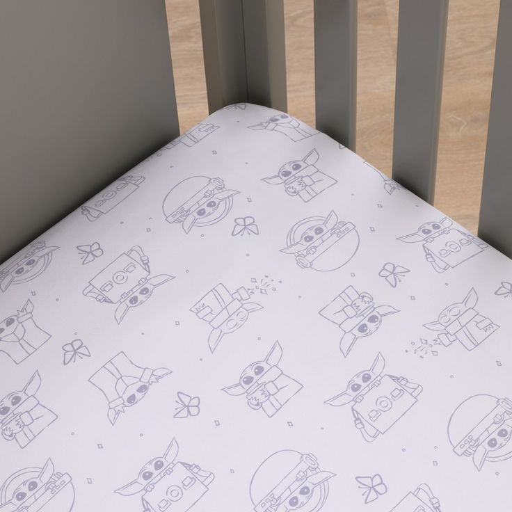 a baby crib bed with an owl print on it's sheet and pillow