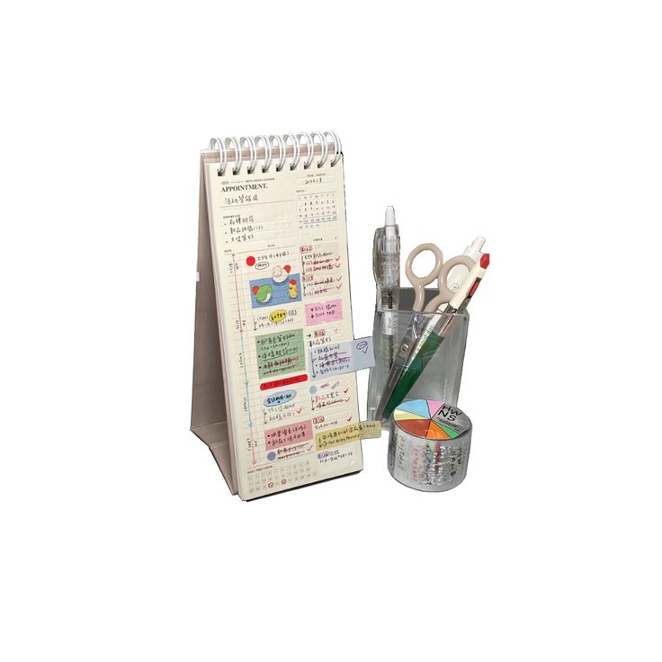 a desk calendar with pens, scissors and markers next to it on a white background