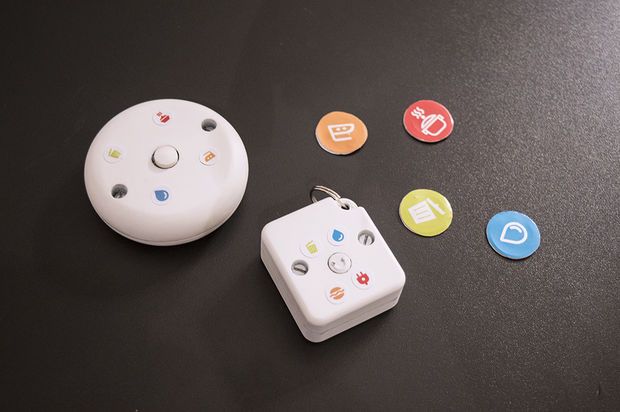 a remote control sitting on top of a table next to several different colored buttons and magnets