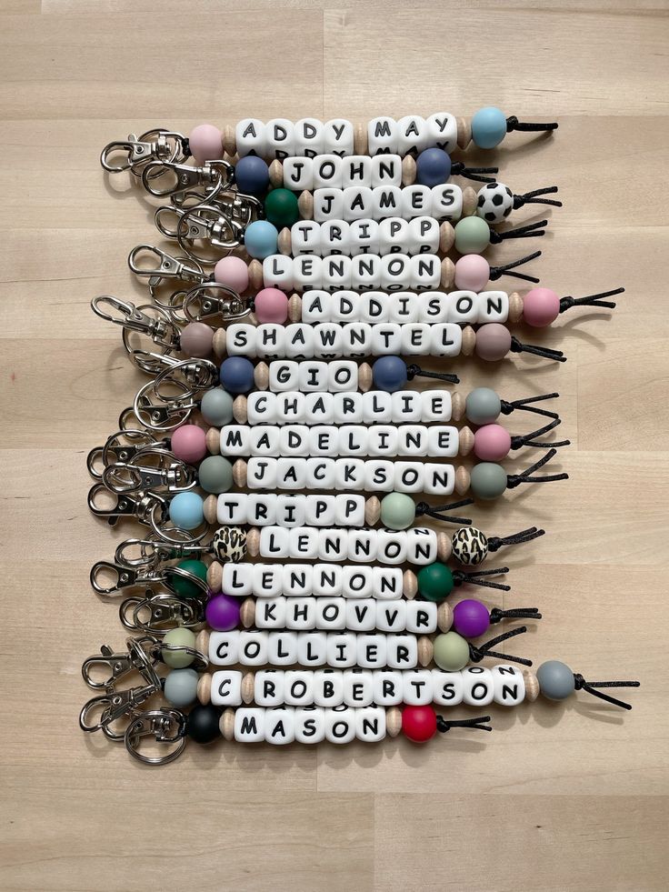 several different types of key chains with words written on them, arranged in the shape of letters