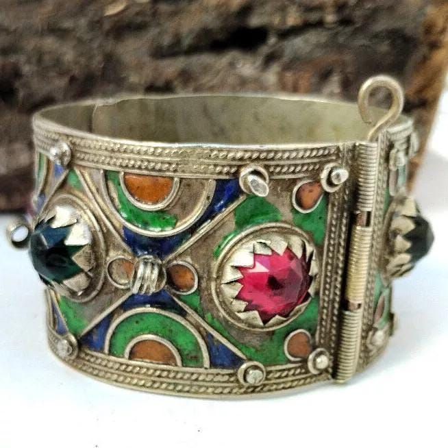 Vintage Moroccan Handmade Berber Silver Bracelet with Glass and enamel - Old Ethnic Jewelry, Handcrafted Berber Bracelet, Old cuff Bracelet A genuine masterpiece of art is this refined artisanal vintage Moroccan Berber bracelet. This piece of jewelry is made of silver and boasts a highly ornate design which demonstrates the deep-rooted tradition of Berber craftsmanship. It has dazzling glass stones and bright enamel work that bring color and stylishness to the band. Every bit of this bracelet is Artisan Bangle As Festival Gift, Artisan Bangle For Festivals And Gifts, Artisan Bangle For Festivals As A Gift, Artisan Bangle As Gift For Festivals, Artisan Bangle As A Gift For Festivals, Bohemian Multicolor Bangle For Ceremonial Occasions, Multicolor Bohemian Bangle For Ceremonial Occasions, Bohemian Multicolor Bangle For Ceremonies, Multicolor Jeweled Enamel Jewelry