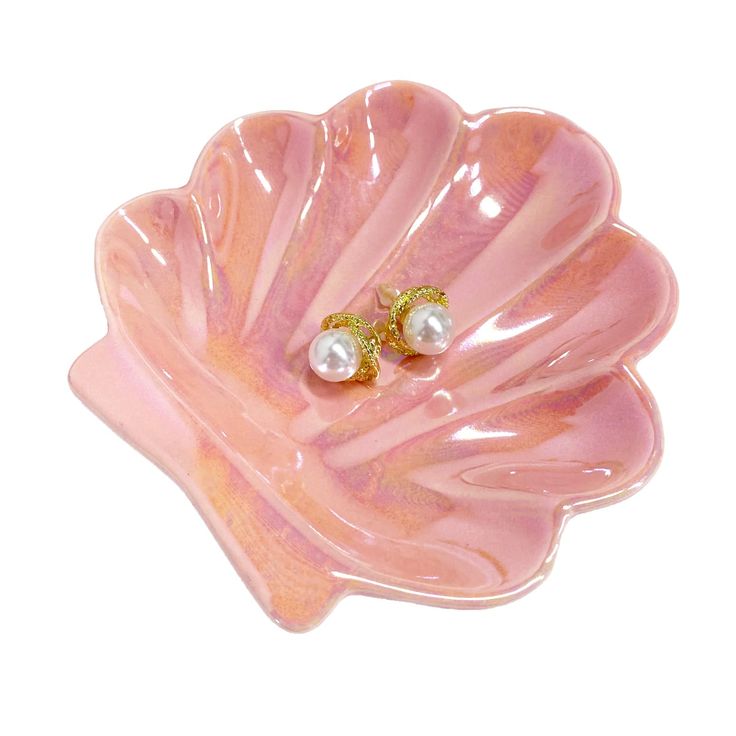 a pink flower shaped dish with pearls on it