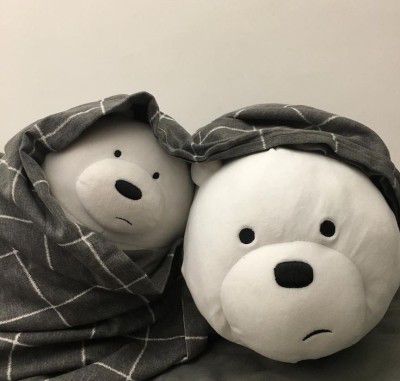 two teddy bears wrapped in blankets on a bed