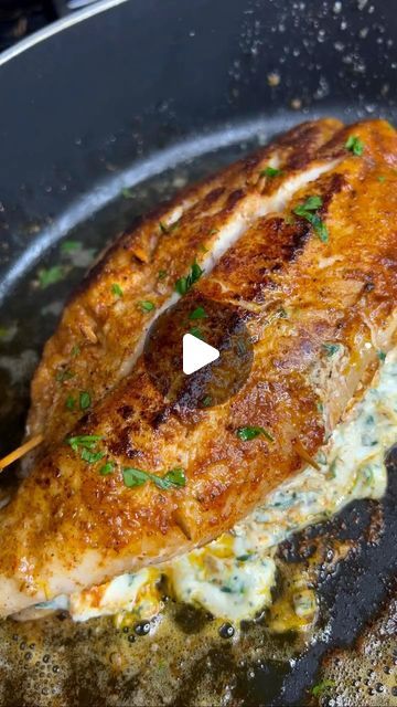 a piece of fish is cooking in a frying pan with some parsley on top