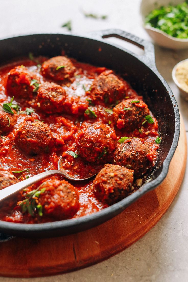 meatballs and sauce in a skillet with a spoon on the side, ready to be eaten