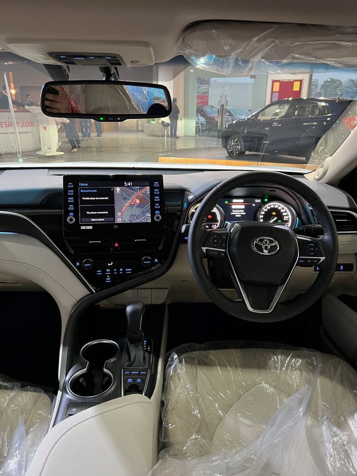 the interior of a car with its dashboard and steering wheel covered in clear plastic bags