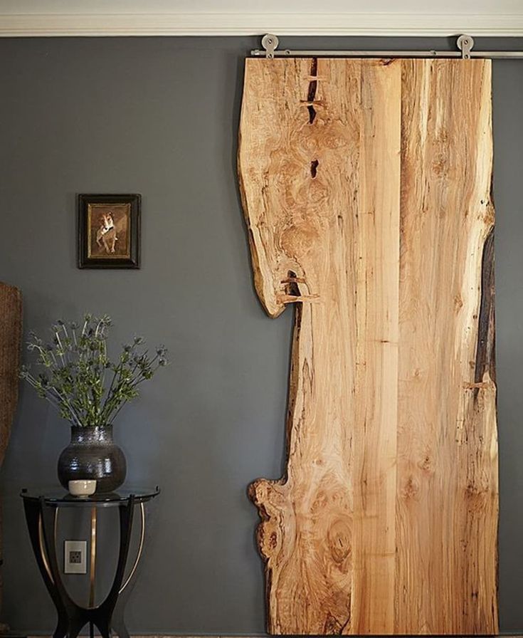 a large wooden piece of wood sitting on top of a hard wood floor next to a table