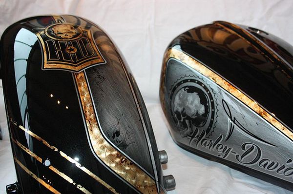 two black and gold motorcycle helmets sitting on top of a white cloth covered tablecloth