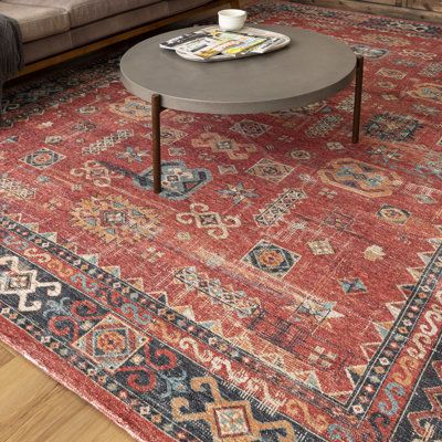 a living room with a couch, coffee table and rug on the floor in front of it