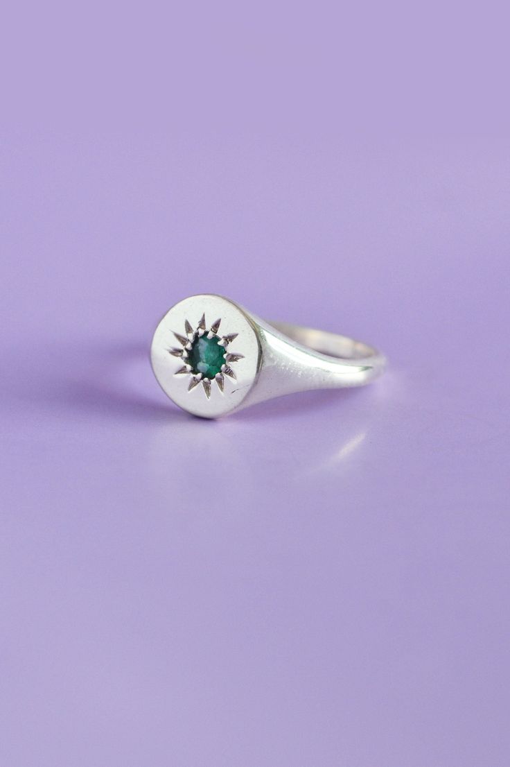 Express your distinct style with our meticulously crafted Daisy Signet Silver Ring. Highlighting a round-cut emerald, skilfully set in sterling silver, this piece seamlessly marries modern and traditional design elements. An embodiment of uniqueness, this exquisite emerald ring is an ideal choice for enhancing your everyday attire.Use the drop down menu to select your ring size and have the ring custom crafted just for you Details925 Sterling Silver jeweleryPersonalised jewellery handcrafted in Timeless Polished Emerald Ring, Emerald Diamond Ring With Polished Finish For Wedding, Wedding Diamond Ring With Polished Emerald, Wedding Emerald Diamond Ring With Polished Finish, Fine Jewelry Green Signet Ring With Birthstone, Elegant May Birthstone Signet Ring, Fine Jewelry Polished Emerald Ring With Round Cut, Timeless Emerald Signet Ring For Anniversary, Green Emerald Diamond Ring With Polished Finish