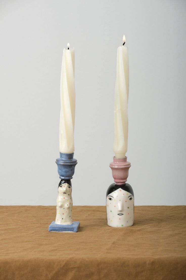 two candles sitting next to each other on top of a table