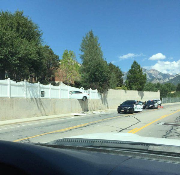 cars parked on the side of a road next to a fence