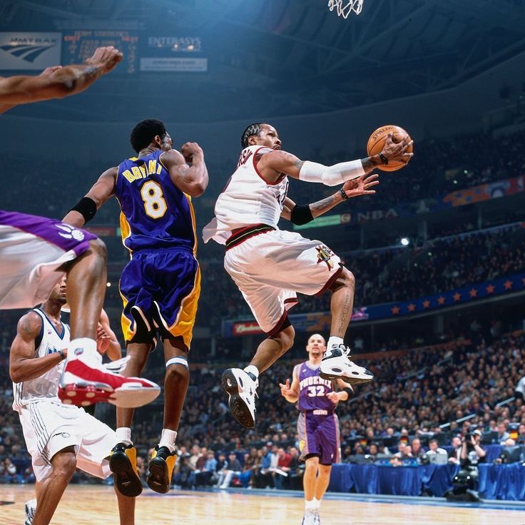 a group of men playing basketball against each other