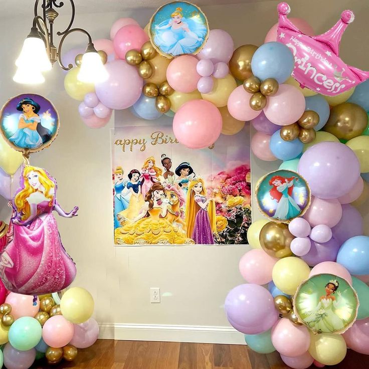 there are many balloons in the room with princesses on them and pictures hanging from the ceiling