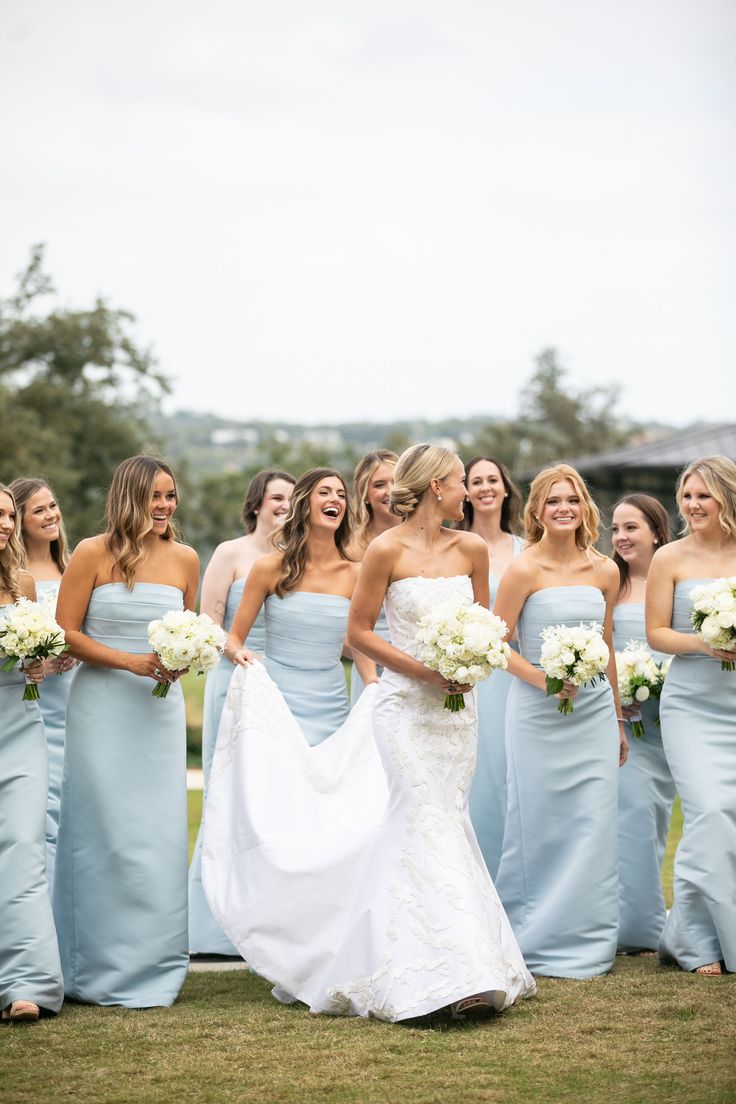 a group of women standing next to each other on top of a lush green field