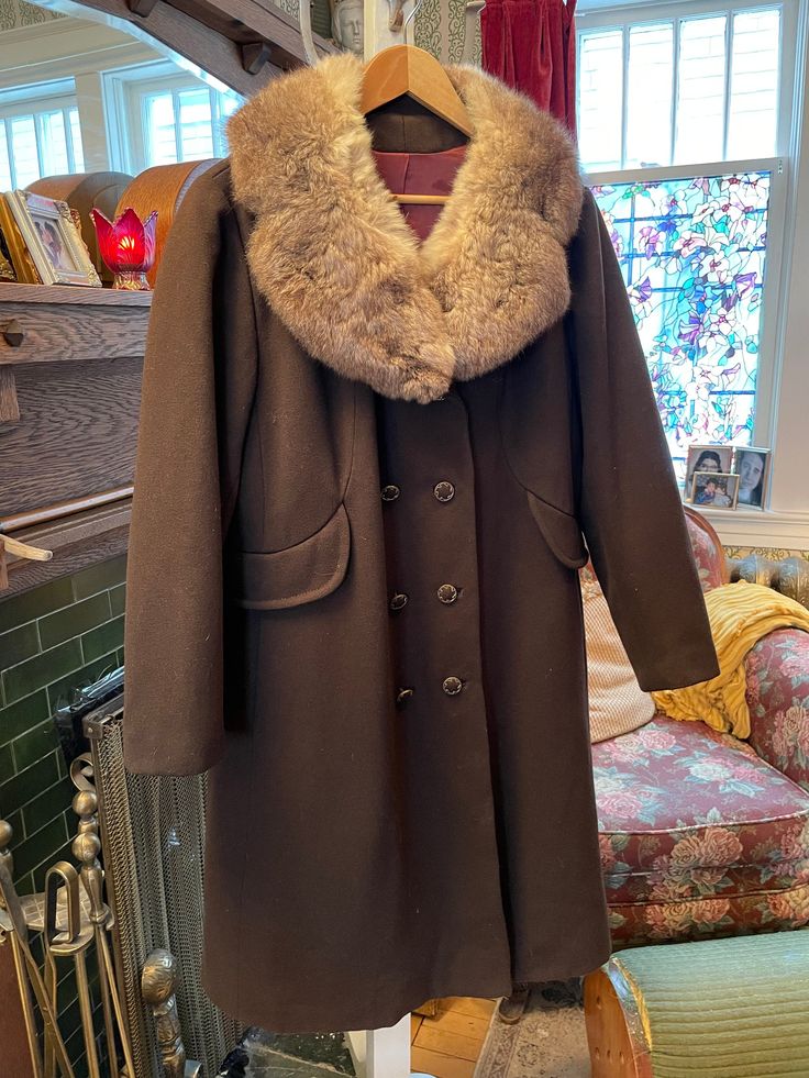 This is an incredible coat made of 100 per cent pure wool in rich chocolate brown with a stunning rabbit fur collar in silky light and medium brown tones. This coat has the original decorative metal and matching wool buttons, two outer pockets and a belt detail at the back. It is fully lined and in excellent condition. The measurements, taken with the coat lying flat, are: shoulder to shoulder, 18 inches; armpit to armpit, 24  inches; sleeves, 23 1/2 inches; overall length, 39 inches; bottom edge, 34 inches. Vintage Outerwear, Brown Rabbit, Long Coat Women, Collared Coat, Brown Tones, Decorative Metal, Vintage Coat, Rabbit Fur, Medium Brown