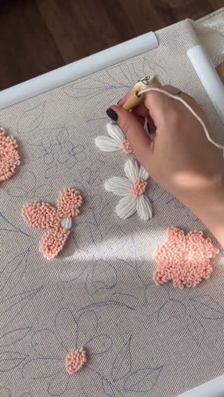 a person is using a sewing machine to sew flowers on a piece of fabric