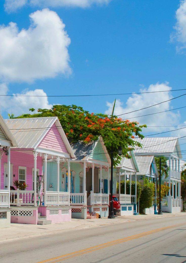 a row of pink and white houses sitting on the side of a road