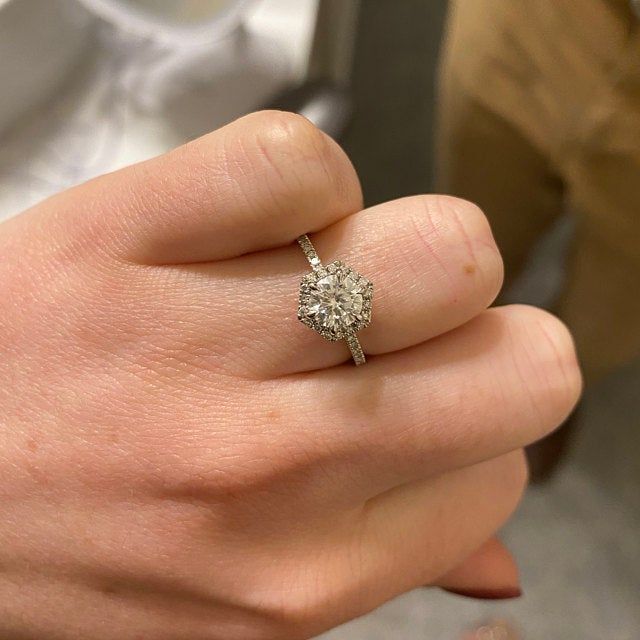 a woman's hand with a diamond ring on it