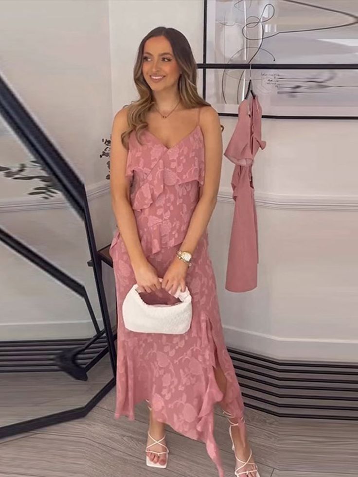 a woman in a pink dress holding a white purse