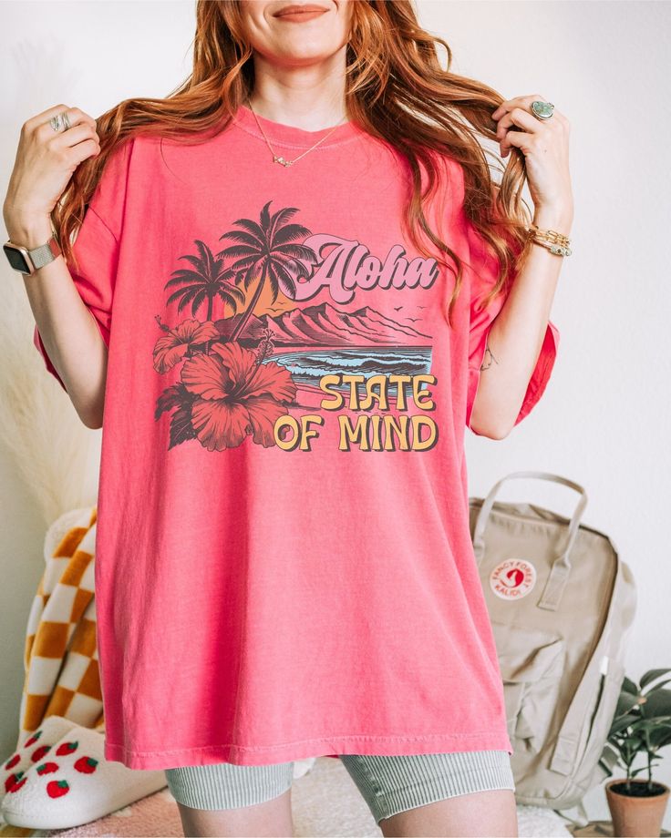 Aloha State of Mind, Aloha Tshirt, Aloha T Shirt, Aloha Shirt/Hawaii T Shirt/Beach Shirt/Vacation Shirts/Hawaii Gifts/Hawaiian Gifts/Summer Gifts Crafted from lightweight cotton that is perfect for active wear or leisure, our Aloha State of Mind shirt offers comfort and style. It's ideal for casual wear, whether going to work, grabbing coffee with friends, or just wanting to wear a comfortable shirt during daily activities. Whether you're curled up on the couch, on the beach, or simply lounging Tropical Print T-shirt For Vacation, Summer Hawaiian Cotton Shirt With Letter Print, Summer Cotton Hawaiian Shirt With Letter Print, Pink Hawaiian Camp Shirt For Beach, Hawaiian Shirt With Letter Print, Hawaiian Short Sleeve Shirt With Letter Print, Pink Tropical Camp Shirt For Vacation, Tropical Pink Camp Shirt For Vacation, Hawaiian Shirt With Letter Print And Short Sleeves