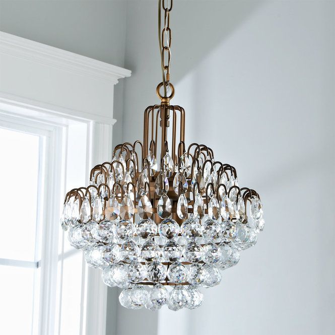 a chandelier hanging from the ceiling in a room with white walls and windows