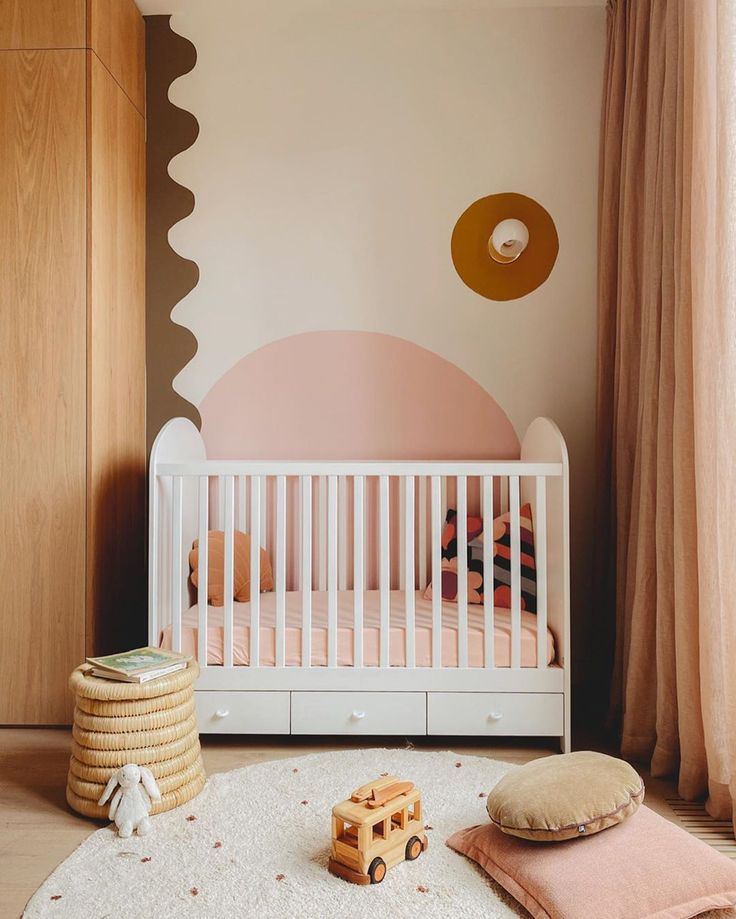 a baby's room with a white crib and pink walls