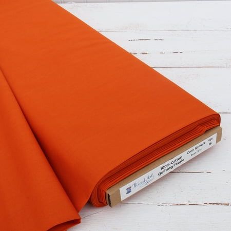 an orange sheet laying on top of a white wooden floor