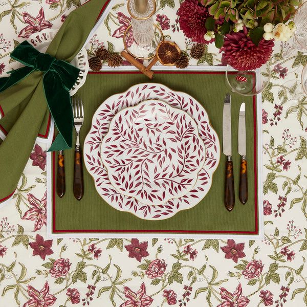 a place setting with red and green napkins, silverware and flowers on the table