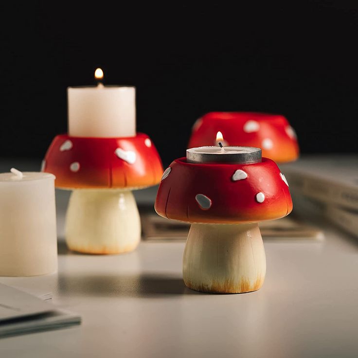 three candles sitting next to each other on top of a table with a laptop computer in the background