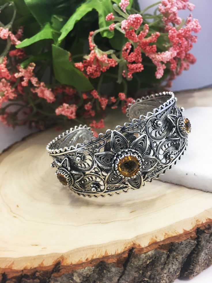 Citrine & Silver Cuff Bracelet 925 Sterling Silver Floral Artisan Crafted Hand Made Filigree Women Jewelry Gifts Boxed P/S or M/L Material: 925 Solid Sterling Silver Genuine Natural Citrine, Center 8 mm cab, 2 side 6 mm each, total 6 carat weight. Cuff Bracelet Weight: 32.5 grams for Medium/Large and 28.5 grams for Petite/Small S/P Size: Adjustable to fit wrists 5 inches to 6.5 inches M/L Size: Adjustable to fit wrists 6.5 inches to 8.5 inches Width: Graduated from 1 inches to 0.50 inches Co Bohemian Bangle Jewelry For Anniversary, Sterling Silver Cuff Bracelet With Gemstone For Wedding, Adjustable Sterling Silver Bracelet With Intricate Design For Anniversary, Adjustable Jewelry With Oxidized Finish For Gifts, Adjustable Oxidized Jewelry For Gifts, Adjustable Oxidized Finish Jewelry For Gifts, Spiritual Adjustable Filigree Jewelry, Ornate Sterling Silver Bangle Jewelry, Intricate Design Bracelet Jewelry For Anniversary