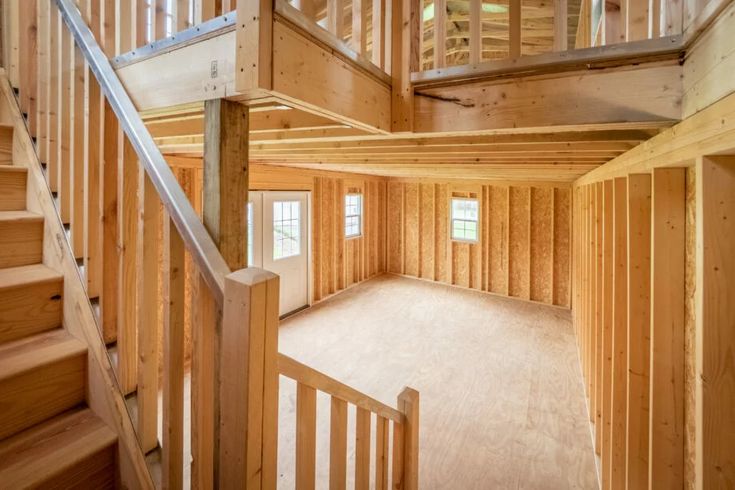 an empty room with wooden walls and stairs