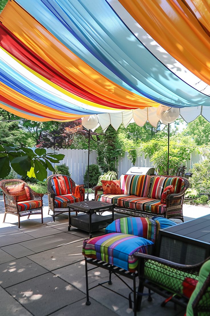 an outdoor patio with colorful striped furniture and umbrellas over the seating area for people to sit on