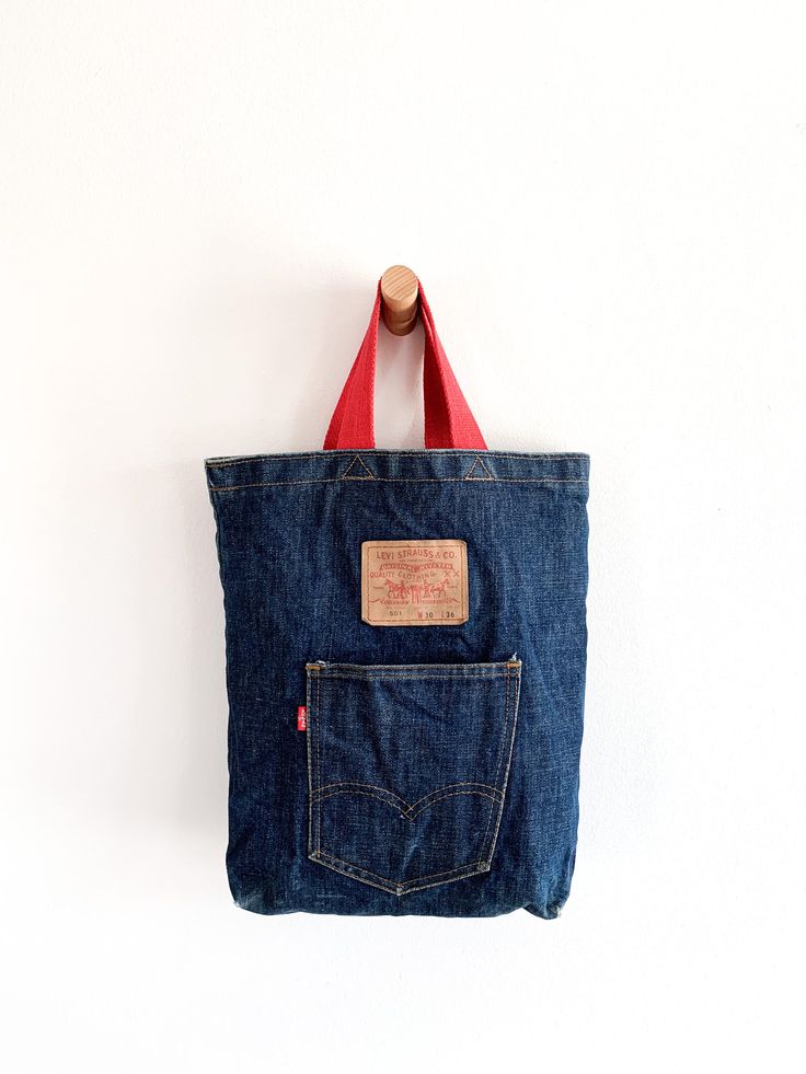 Red handled dark denim Levi’s tote bag or purse. 10.5"(w) x 14.5"(h) x 3"(d)Handle drop 5.5” Condition: Very good. One ink spot on bottom (see photo). Denim Tote Bags, Denim Tote, Levi Strauss & Co, Levi Strauss, Dark Denim, Spot On, 3 D, Purse, Tote Bag