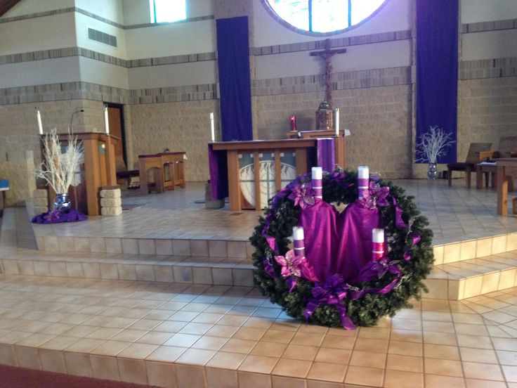 a purple wreath is placed on the steps in front of a church alter with candles