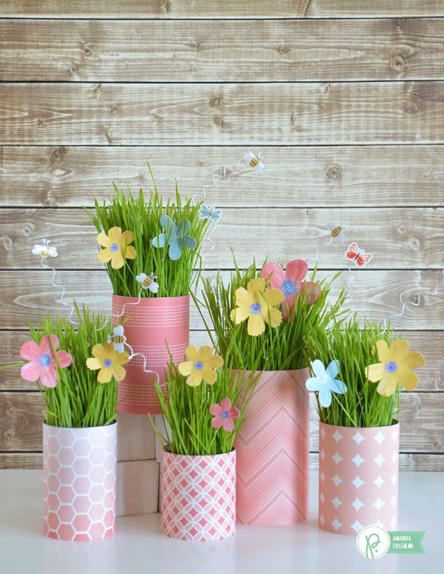 four pink vases with grass and flowers in them