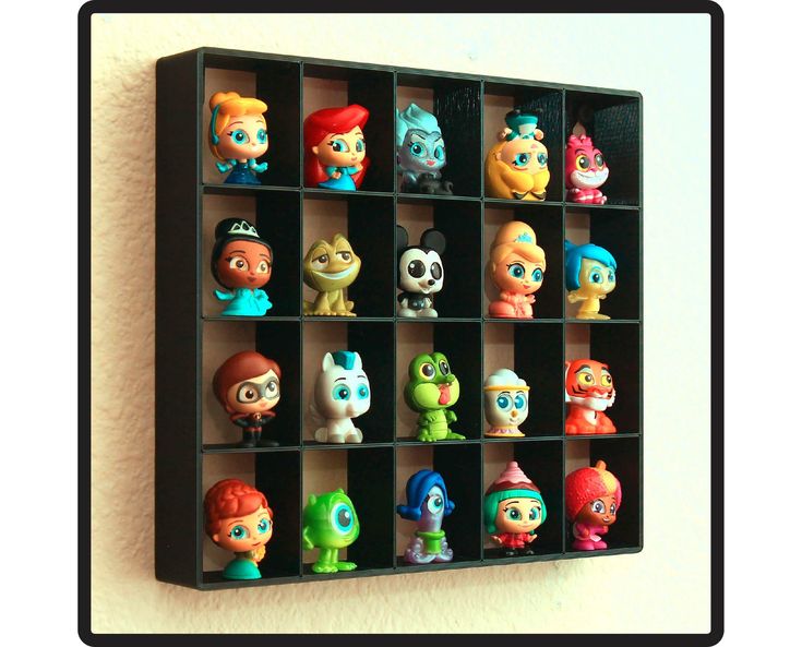 there are many small toy figures in the shelf on the wall behind it is a black frame