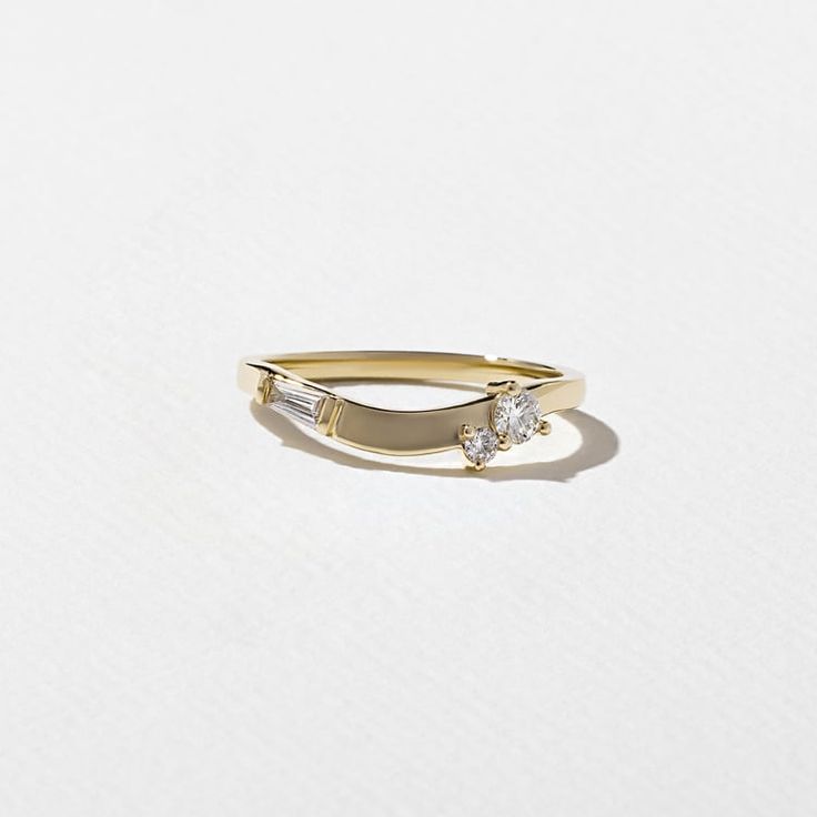 a gold ring with two diamonds on it